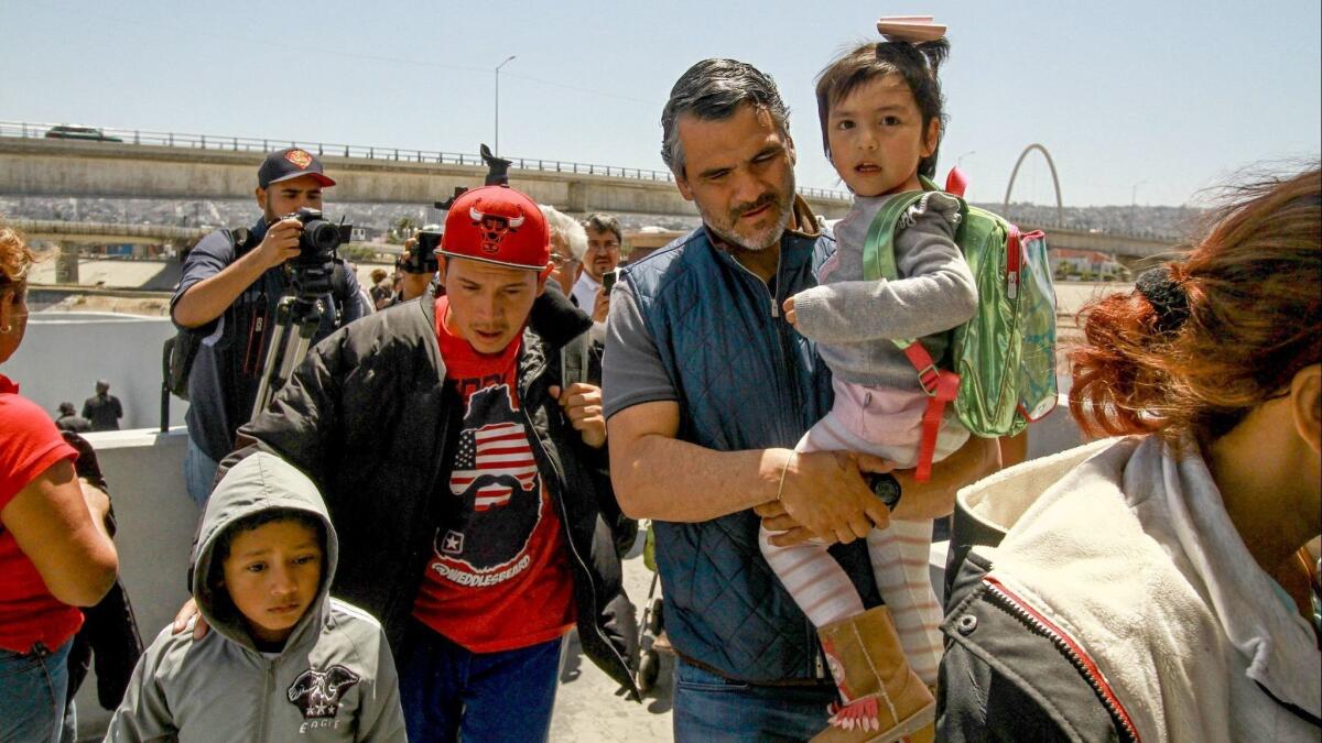 Central American migrants cross into the United States at the El Chaparral border crossing, in Tijuana, Mexico, on May 4.