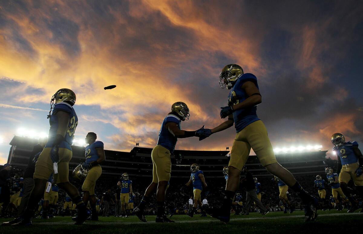 UCLA football players warm up before a game against rival USC.