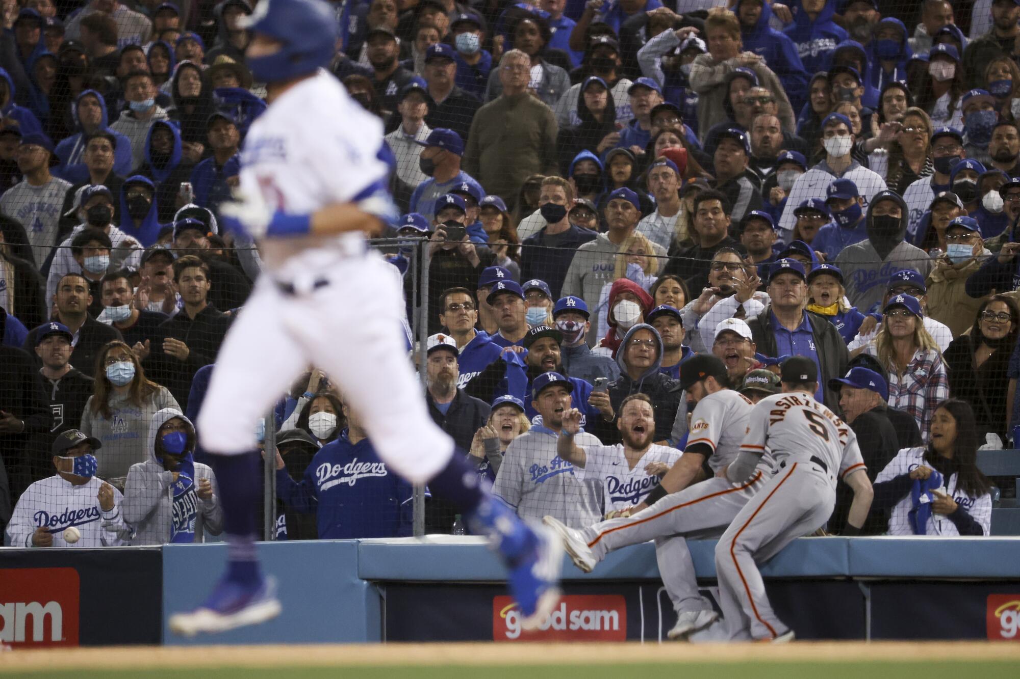 San Francisco Giants first baseman Kris Bryant, center, and Mike Yastrzemski, right, are unable to track down a foul ball hit