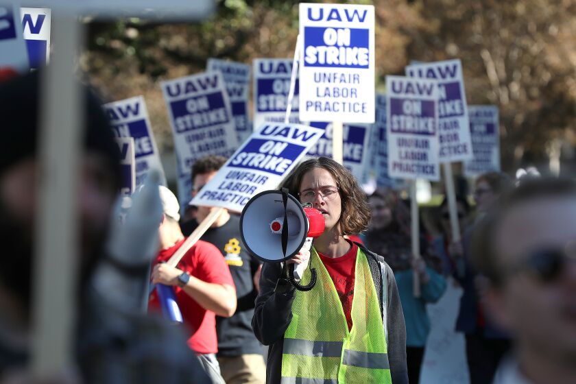 UCI students walk the campus ring mall road past the student union building in support of 48,000 unionized academic workers across the University of California system, who went on strike, including UCI on Monday
