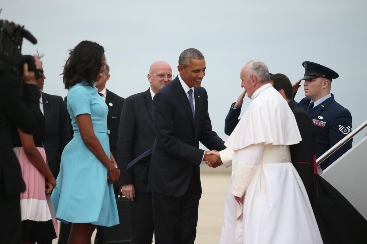 El presidente Barack Obama y su esposa Michelle Obama dan la bienvenida al papa Francisco a su llegada a la base Andrews el martes 22 de septiembre de 2015.