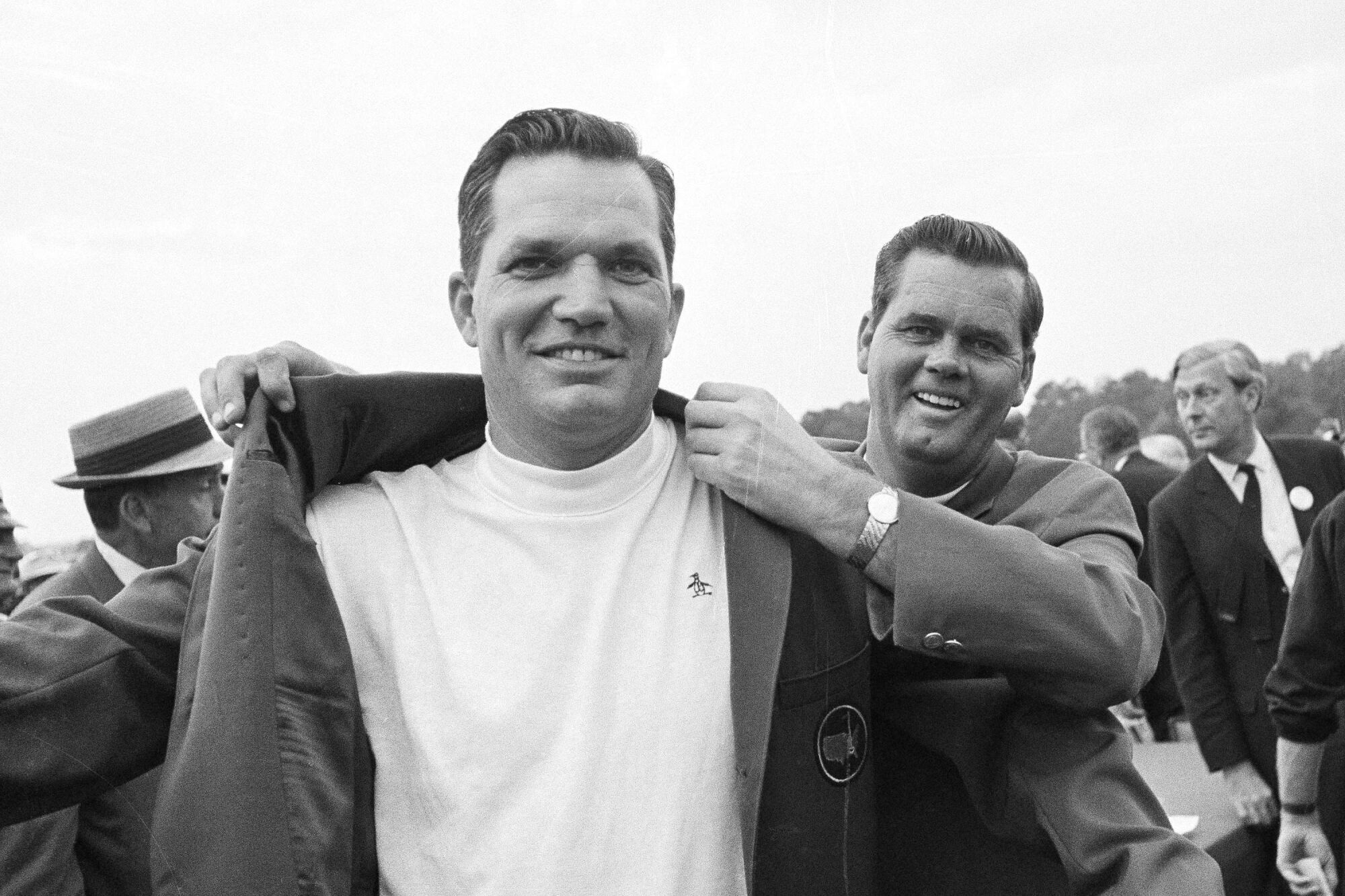Bob Goalby puts on the traditional green jacket as champion of the Masters in a black and white photo
