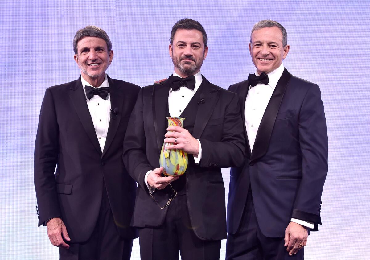 Children's Hospital Los Angeles Chief Executive Paul Viviano, left, and Walt Disney Co. Chairman and Chief Executive Bob Iger, right, present a Courage to Care Award to TV host Jimmy Kimmel during the Children's Hospital Los Angeles gala at L.A. Live in Los Angeles.