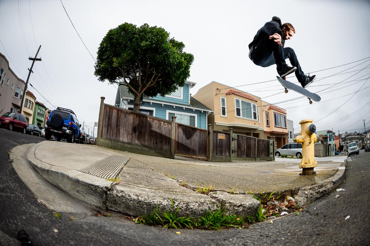 Walker Ryan does a kickflip from the curb cut over a fire hydrant.