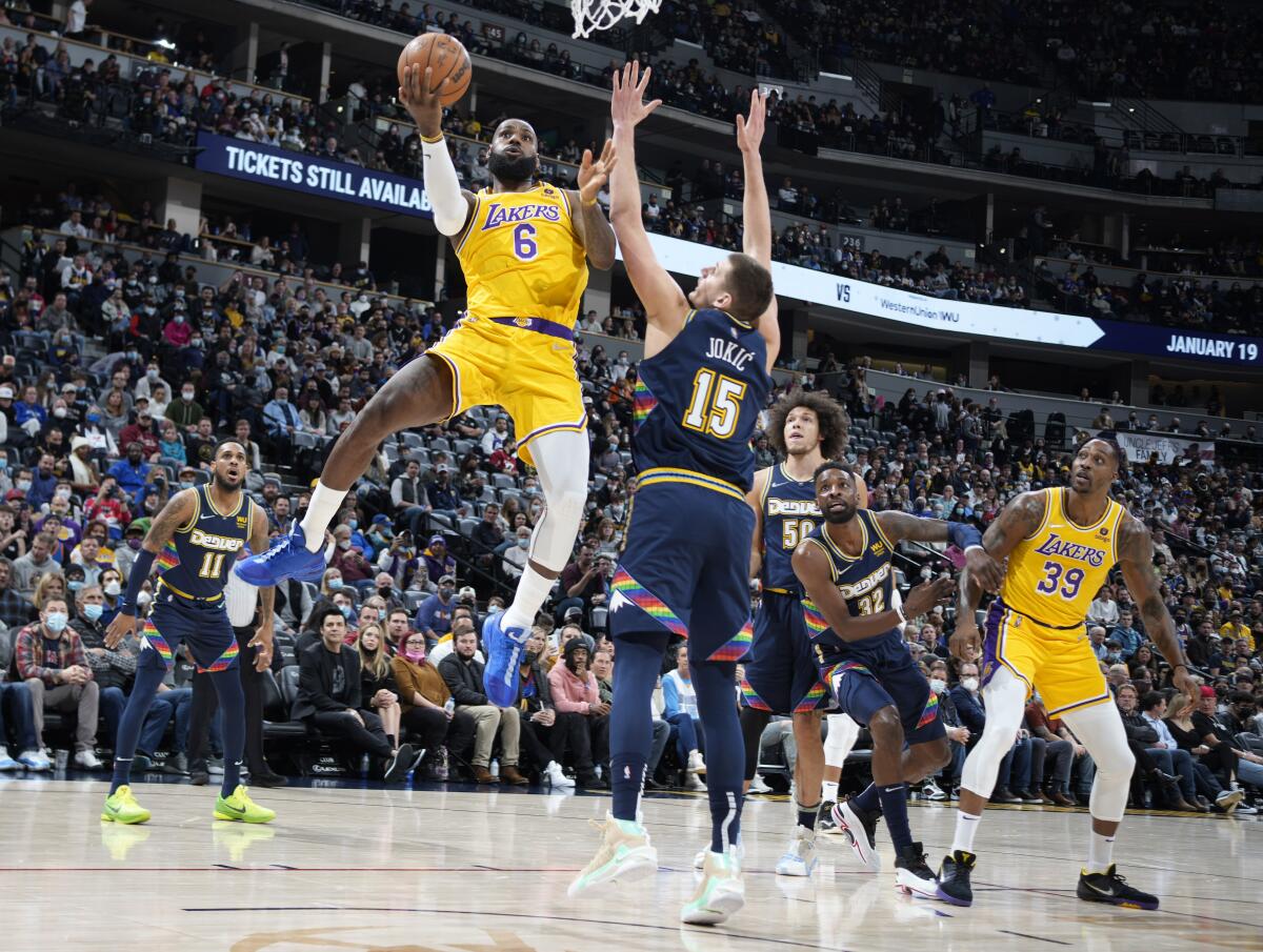 Lakers star LeBron James shoots as Denver Nuggets center Nikola Jokic defends during the first half.