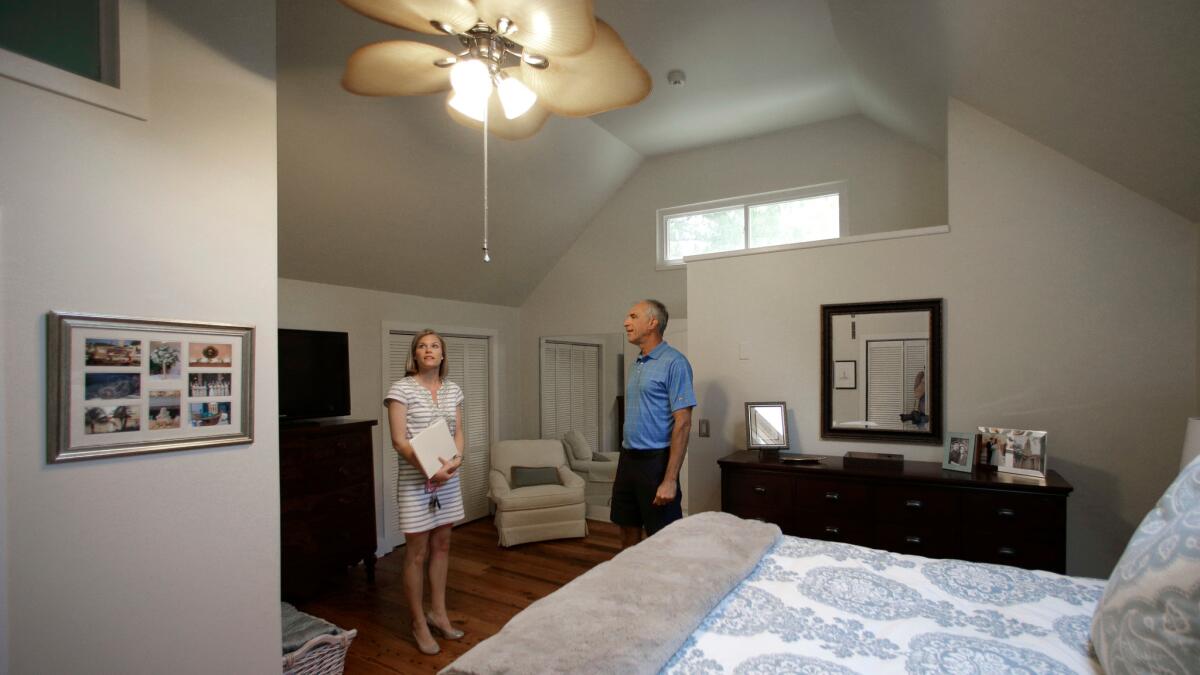 Real estate agent Lauren Newman, left, shows client Steve Martin a home for sale in Mount Pleasant, S.C., in April.