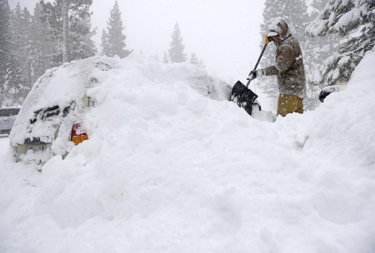Jake Coleman digs out his car along North Lake Boulevard as snow continues to fall in Tahoe City.