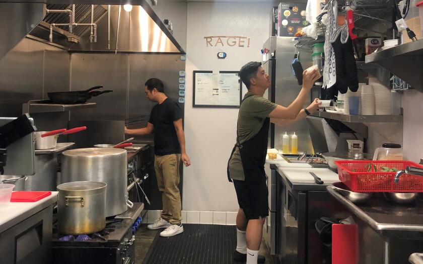 Mo'Betta Noodlery business partners Allen Phomassa and Anthony Nguyen prepare lunch time orders at the Barrio Food Hub.