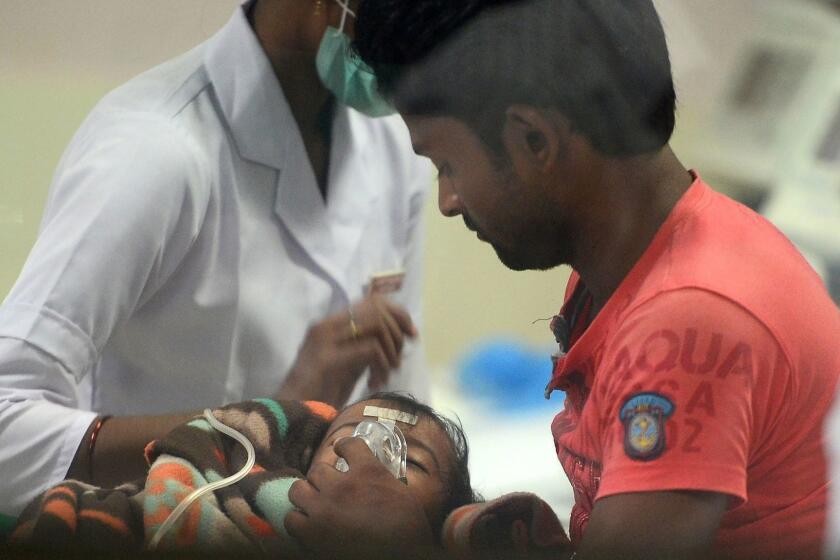 Indian medical staff and relatives attend to a child admitted in the Encephalitis ward at The Baba Raghav Das Hospital in Gorakhpur, in the northern Indian state of Uttar Pradesh, on August 12, 2017. At least 60 children have died over five days at a government hospital in northern India that suffered oxygen shortages, officials said August 12, amid fears the toll could rise. Authorities said they have launched an inquiry but denied reports that a lack of oxygen had caused the deaths at the Baba Raghav Das Hospital in Gorakhpur district in Uttar Pradesh state, which is ruled by Prime Minister Narendra Modi's Bharatiya Janata Party. / AFP PHOTO / SANJAY KANOJIASANJAY KANOJIA/AFP/Getty Images ** OUTS - ELSENT, FPG, CM - OUTS * NM, PH, VA if sourced by CT, LA or MoD **