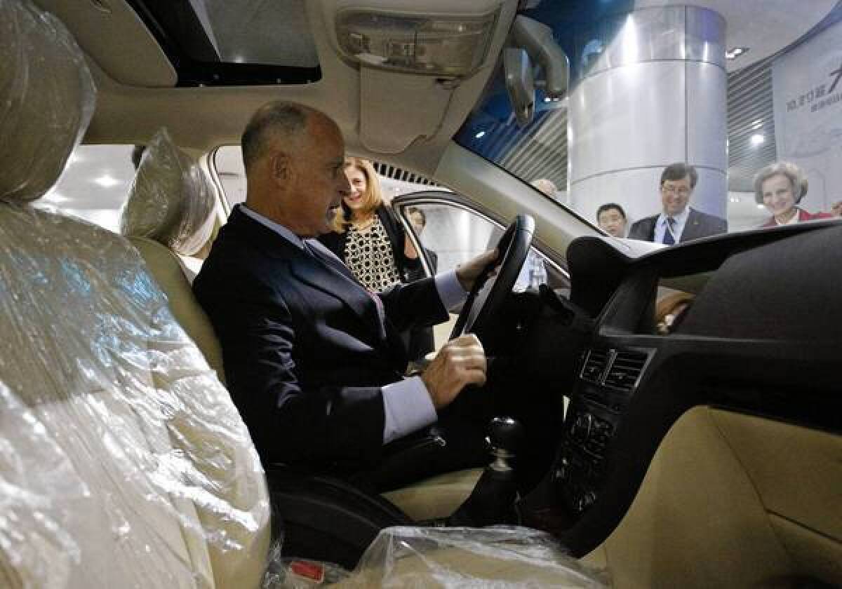 California Gov. Jerry Brown sits in an electric car during a visit to the Shenzhen, China, headquarters of automaker BYD on Tuesday.