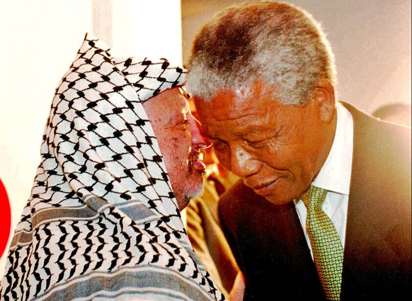 Palestinian Liberation Organization Chairman Yasser Arafat speaks with Mandela in Tunis in 1994 during an African summit. Arafat was an observer at the summit.