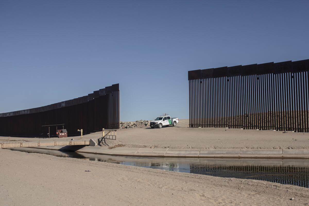 A truck waits at a border fence