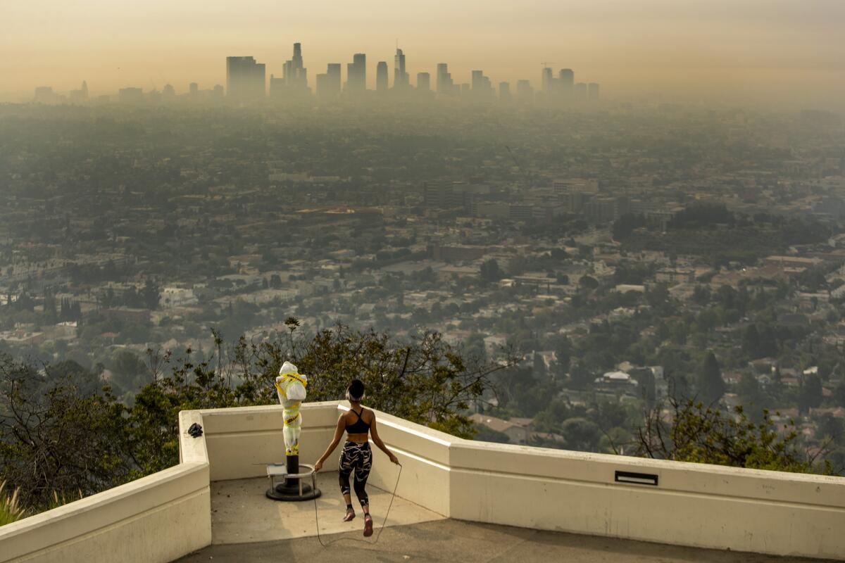 A person jumps rope at Griffith Observatory to exercise in spite of dense smoke from wildfires.
