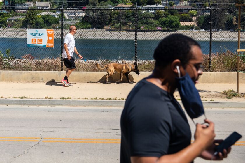 LOS ANGELES, CA - MAY 04: Signs posted along the Silver Lake Reservoir work to keep people moving in one direction, this side moving south along W. Silver Lake Drive, on a warm day in Los Angeles, CA, Monday, May 4, 2020, during the coronavirus pandemic. (Jay L. Clendenin / Los Angeles Times)
