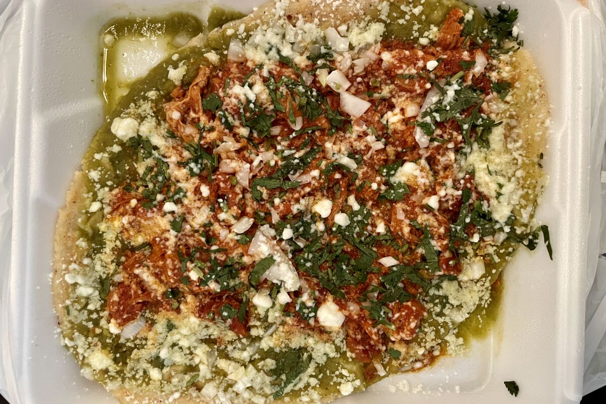 overhead view of masa topped with vegetables and salsas