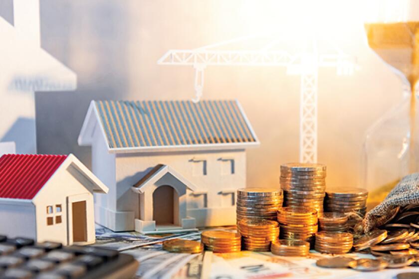 Real estate or property development. Construction business investment concept. Home mortgage loan rate. Coin stack on international banknotes with calculator, house and crane models on the table.