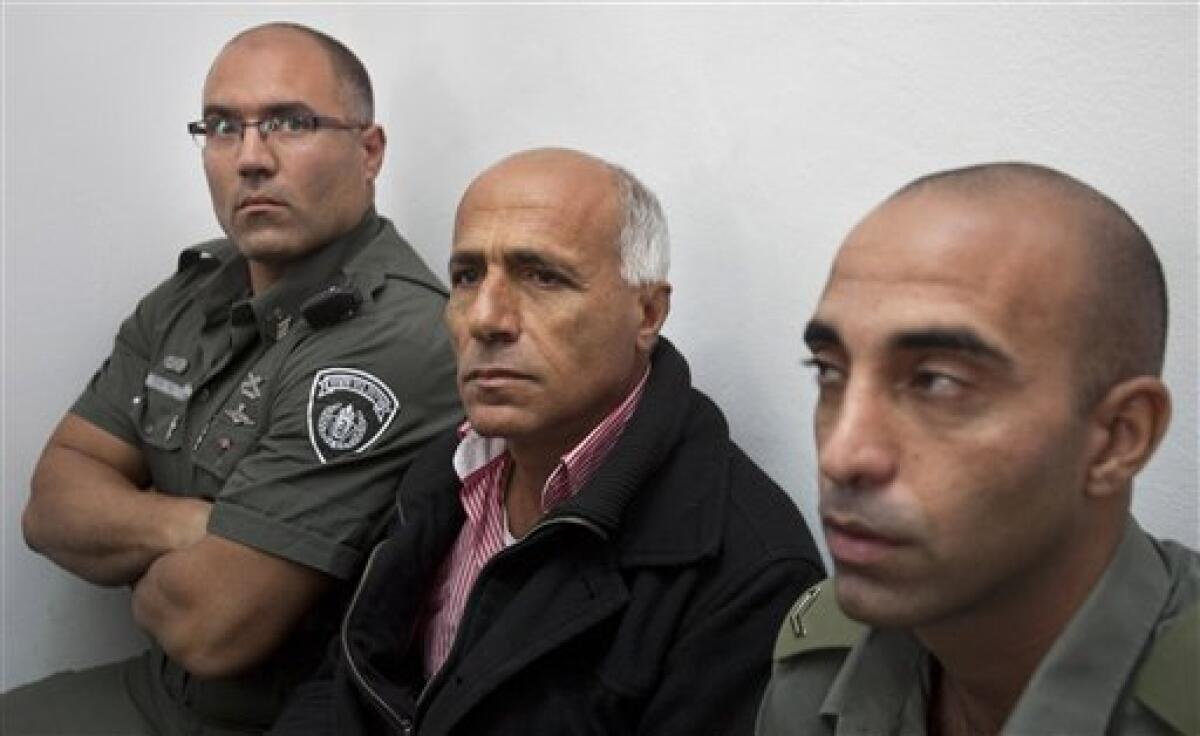 Israeli nuclear whistleblower Mordechai Vanunu, center, sits between two prison guards as he waits in a courtroom before a hearing, in Jerusalem, Tuesday, Dec. 29, 2009. Vanunu was put under house arrest Tuesday after being charged with violating a condition of his 2004 release from an Israeli prison. Vanunu was a former low-level technician at an Israeli nuclear plant who leaked details and pictures of the operation to the Sunday Times of London in 1986. Vanunu served 18 years in prison and after his release was banned from leaving the country and having unauthorized contact with foreigners.(AP Photo/Dan Balilty)