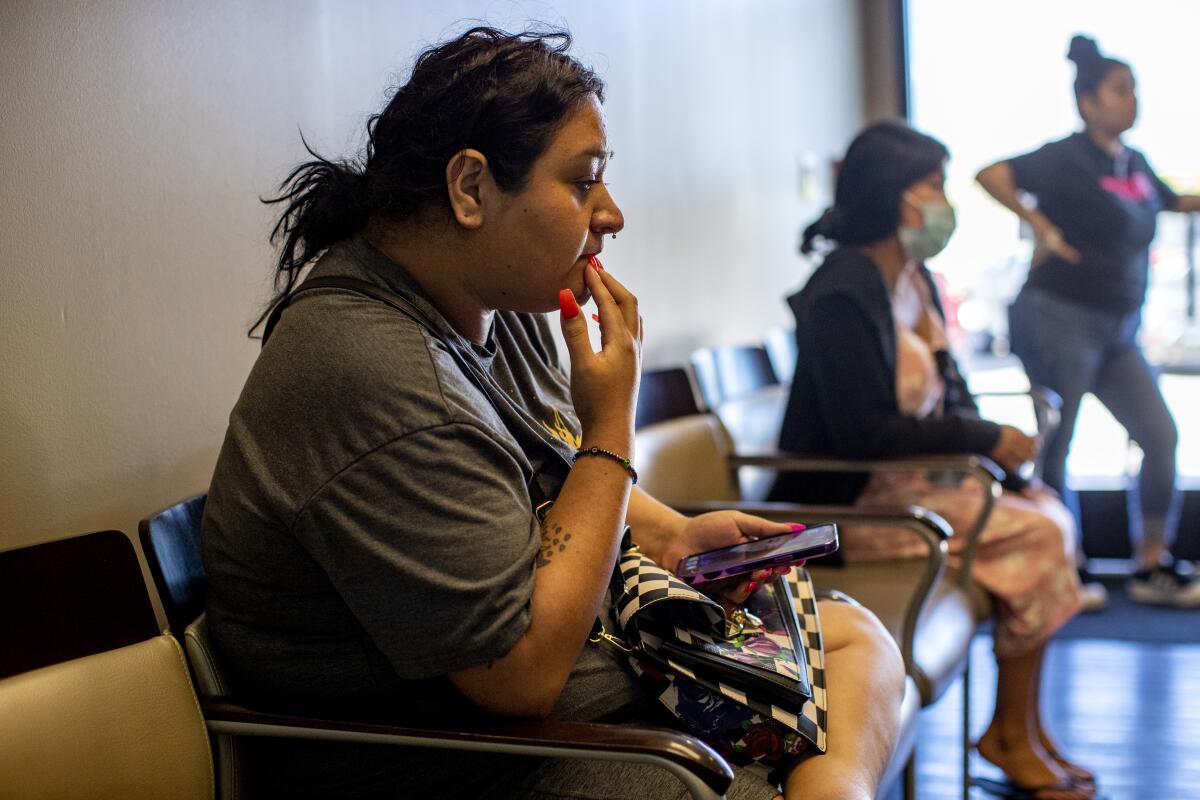 A woman looks pensive in a waiting room