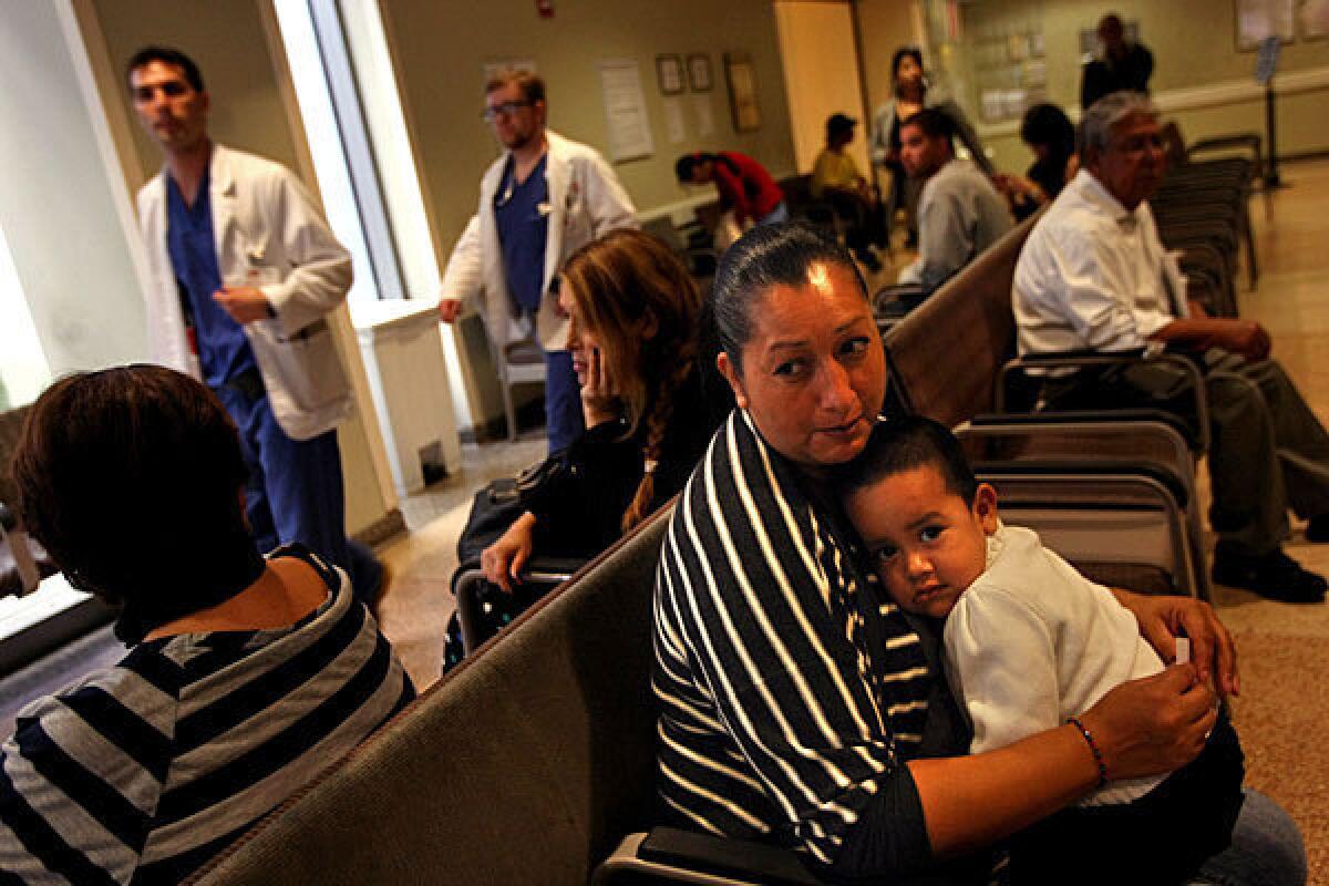 Medi-Cal patient Elizabeth Martinez and her son Maximiliano, 2, wait to see a doctor in the emergency ward of L.A. County-USC Medical Center in October.