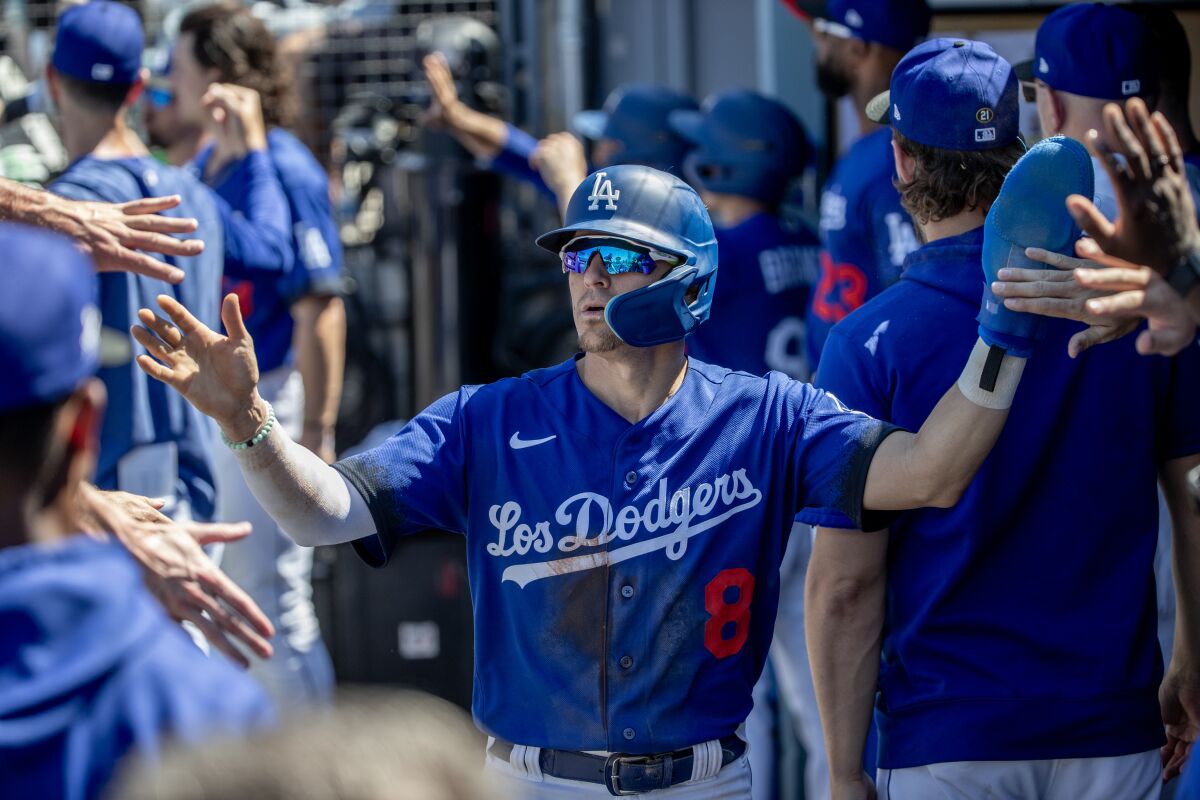 Kiké Hernández celebrates in the dugout after scoring on a sacrifice fly by Miguel Rojas against the Colorado Rockies.