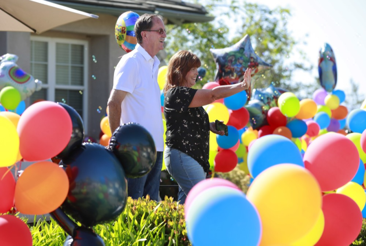 Walt Ekard, along with his wife Pam, react to well wishers during a drive-by “get well soon” event at his Alpine home on May 24. Ekard says treatment is going well after recently being diagnosed with pancreatic cancer.