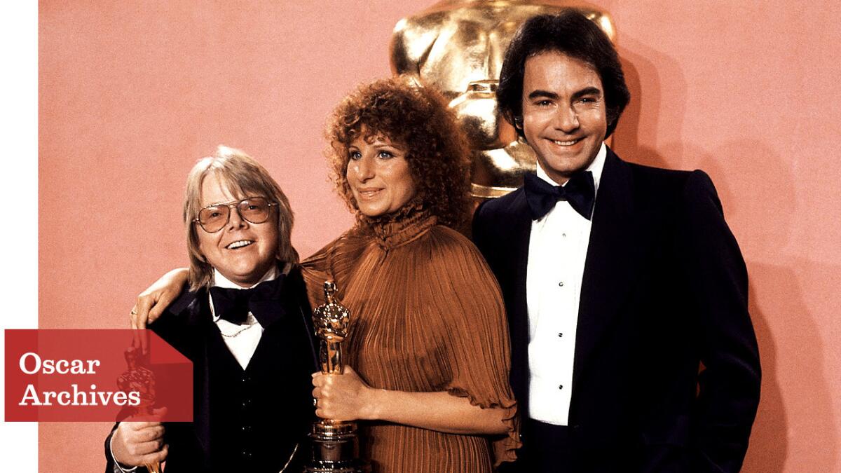 Paul Williams, left, and Barbra Streisand hold their Oscars for best original song, for "Evergreen" from "A Star is Born," backstage with presenter Neil Diamond.