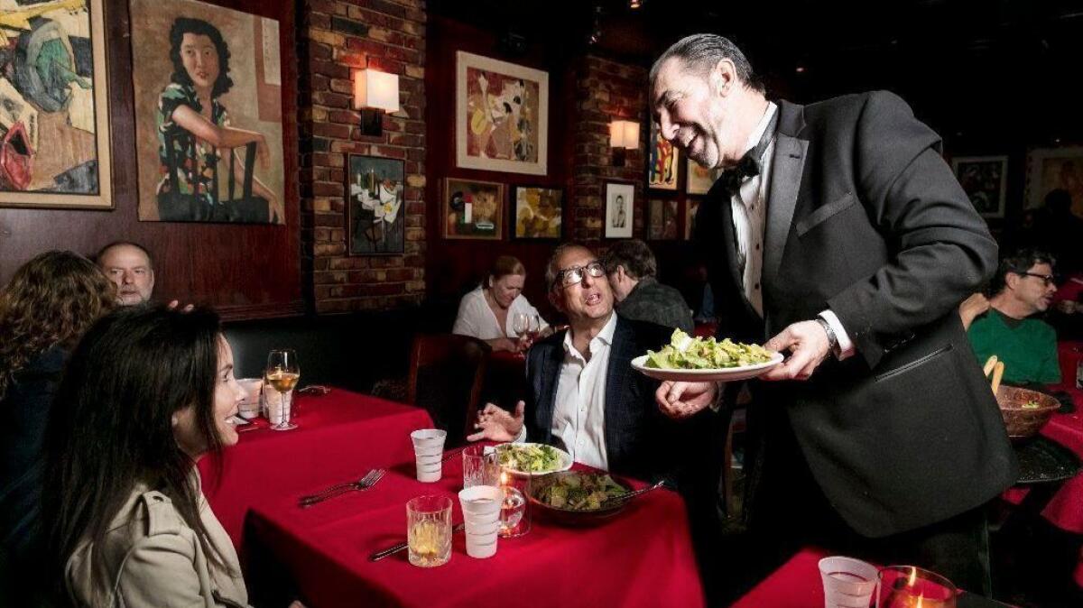 Dining room captain Hank Kelly prepares a Caesar salad table-side at Dear John's.