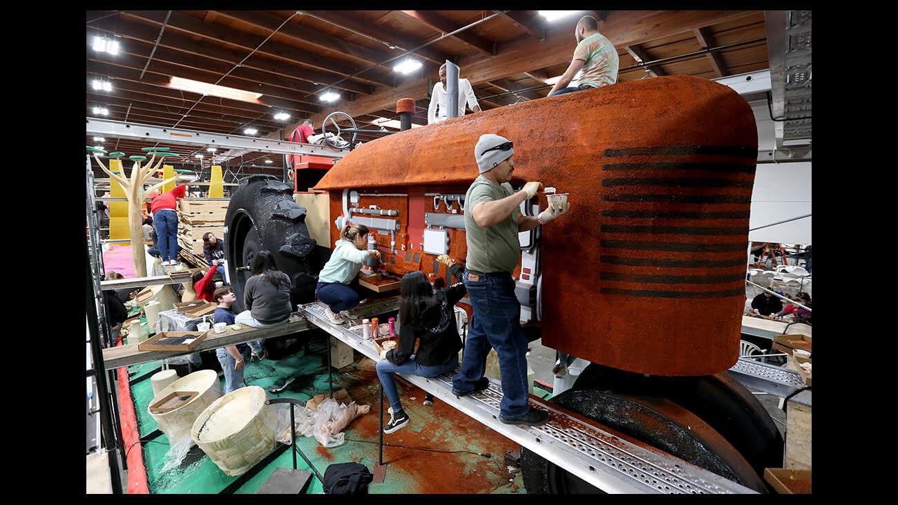 Antonio Garcia and other volunteers decorate Chipotle Mexican Grill's Rose Parade float at the Rosemont Pavilion in Pasadena on Friday. The float, which has a tractor centerpiece, is made with foodstuffs from Chipotle's menu.