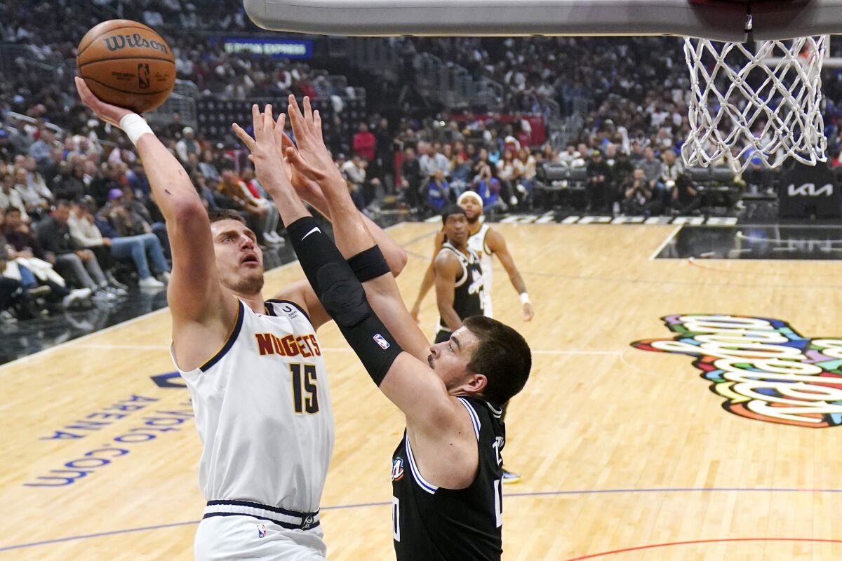 Denver Nuggets center Nikola Jokic, left, shoots as Los Angeles Clippers center Ivica Zubac defends during the first half of an NBA basketball game Friday, Nov. 25, 2022, in Los Angeles. (AP Photo/Mark J. Terrill)