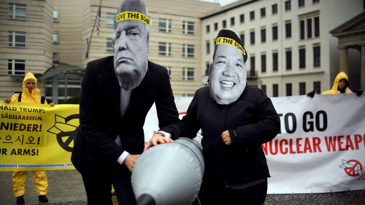 Members of the International Campaign to Abolish Nuclear Weapons, wearing masks of President Trump and North Korean leader Kim Jong Un, protest the U.S.-North Korea conflict at the U.S. Embassy in Berlin.