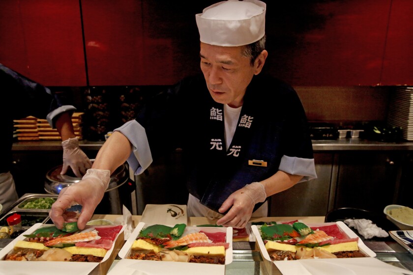 A sushi chef wears gloves as he prepares food at Sushi Gen in Los Angeles on Jan. 17.