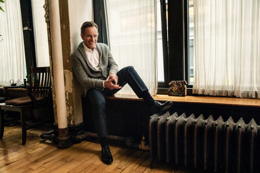 Bryan Cranston on a window seat in a New York apartment.