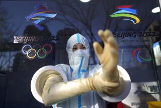 A worker prepares to administer a COVID-19 test at the 2022 Winter Olympics, Tuesday, Feb. 1, 2022, in Beijing. (AP Photo/David J. Phillip)