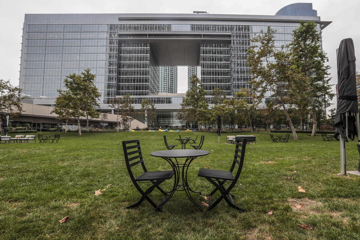Small tables and chairs outdoors with a big building the background.