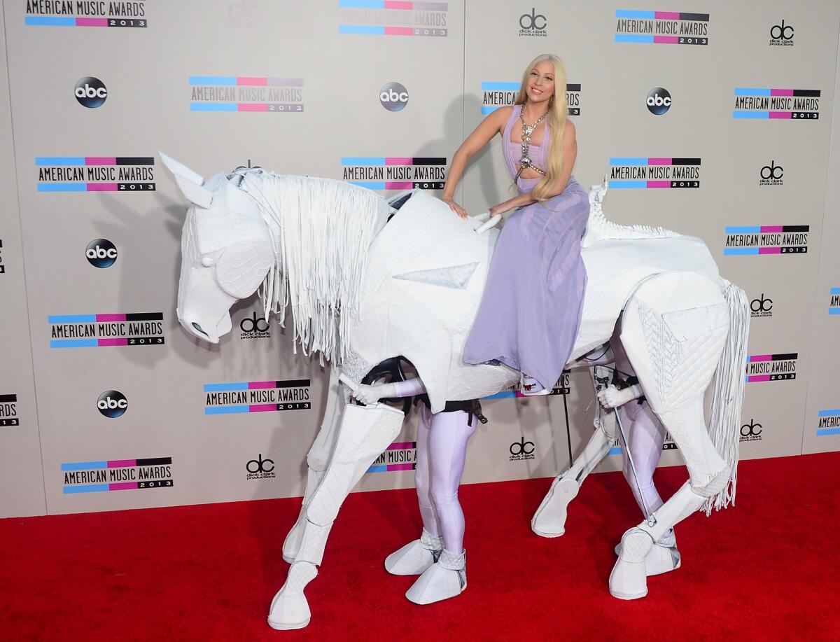 Lady Gaga, wearing Versace, arrives via "horse" for the 2013 American Music Awards.