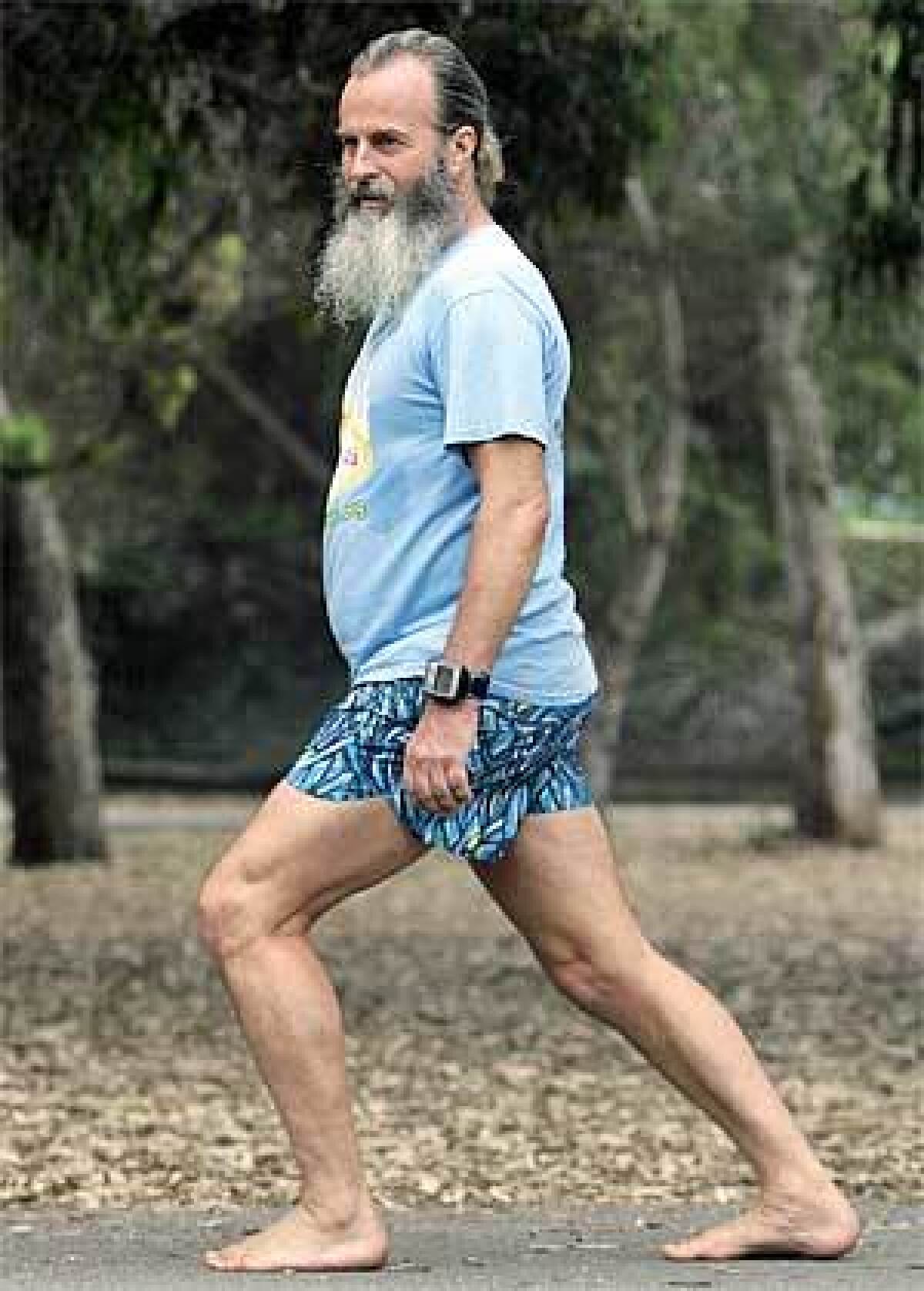 Instructor Ken Saxton demonstrates proper barefoot running posture: vertical back, bent knees and as large part as possible of the foot's surface touching the ground, after a barefoot running clinic in Huntington Beach.