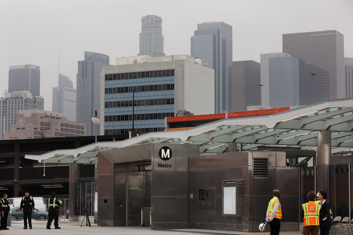 The entrance to the new Little Tokyo/Arts District Station is shown with the downtown L.A. skyline in the background.