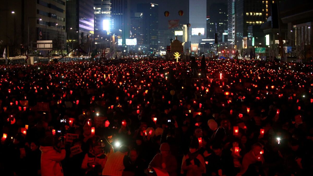 South Koreans gather with candles during a rally against President Park Geun-hye on a main street in Seoul on March 4, 2017.