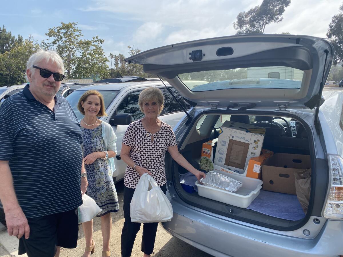 Volunteers Jan Greenberg, Heidi Ryan and Jeanne Karcher of Welcome INN serve food at Doheny State Beach on June 16. 