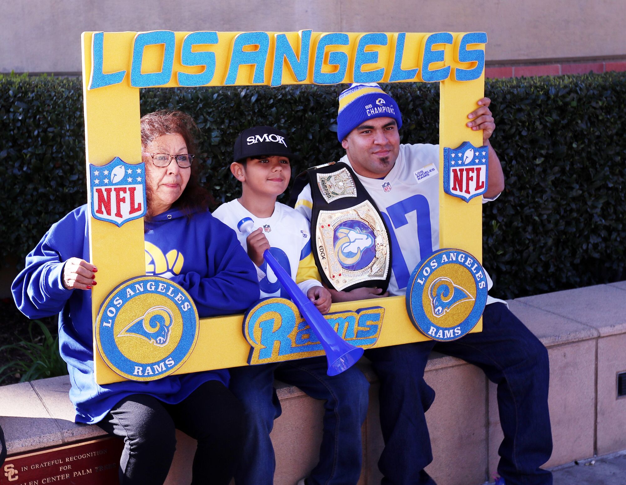 A family of Rams fans holds a sign shaped like a giant photo frame.