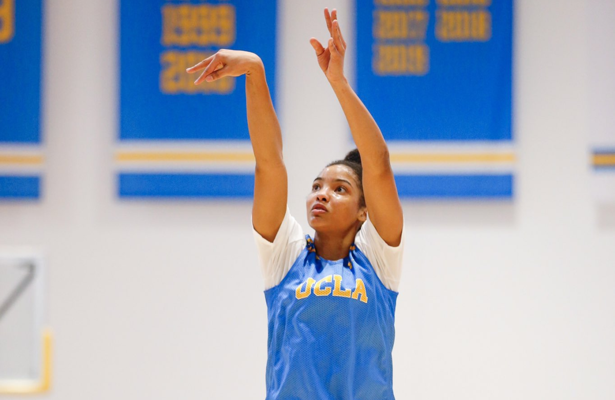 Dominique Darius, in UCLA uniform, finishes a shot to the hoop.