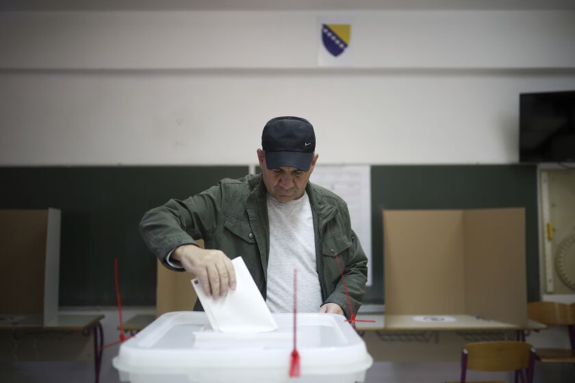 Bosnian man casts his vote at a poling station in Sarajevo, Bosnia, Sunday, Oct. 2, 2022. Polls opened Sunday in Bosnia for a general election that is unlikely to bring any structural change despite palpable disappointment in the small, ethnically divided Balkan country with the long-established cast of sectarian political leaders. (AP Photo/Armin Durgut)