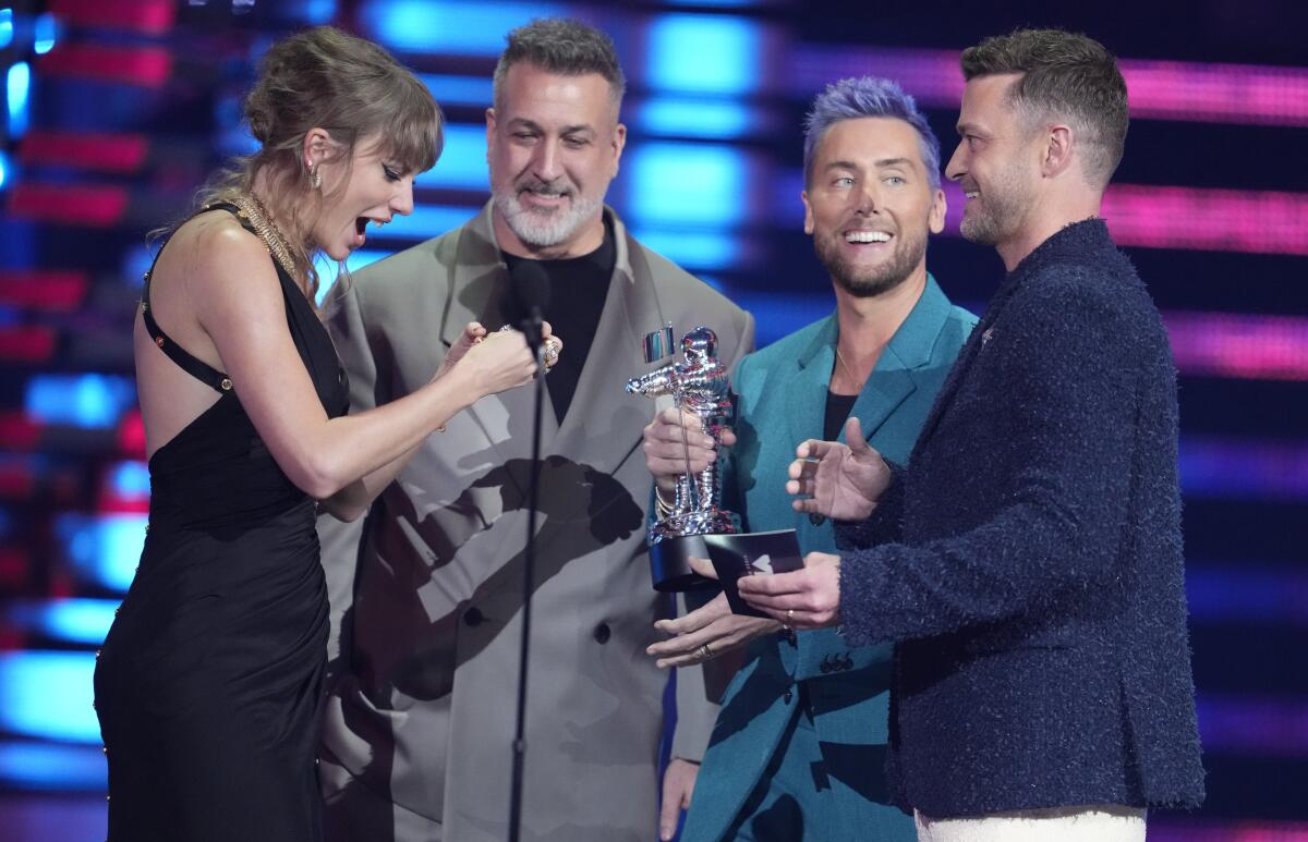 Joey Fatone, Lance Bass and Justin Timberlake present an award to Taylor Swift.