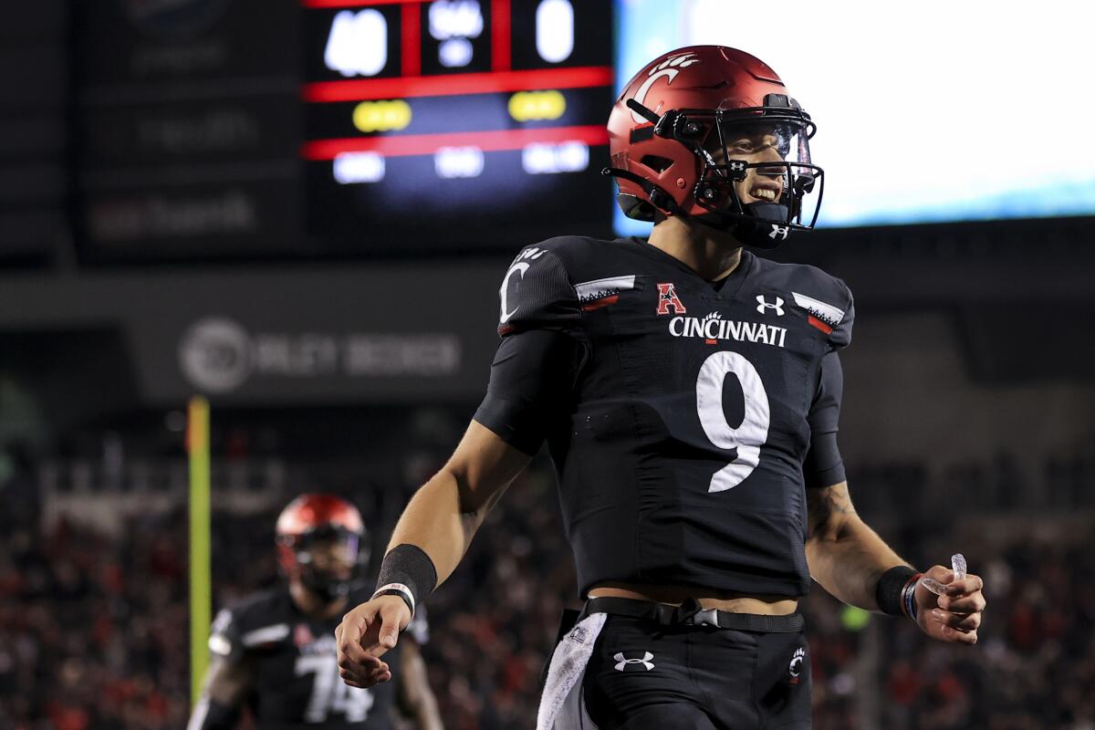 Cincinnati quarterback Desmond Ridder celebrates with teammates after throwing a touchdown.