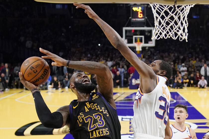Los Angeles Lakers forward LeBron James, left, shoots as Phoenix Suns forward Kevin Durant defends during the second half of an NBA basketball In-Season Tournament quarterfinal game Tuesday, Dec. 5, 2023, in Los Angeles. (AP Photo/Mark J. Terrill)