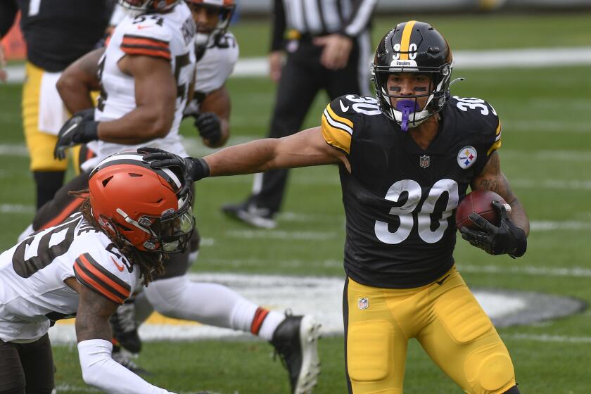 Pittsburgh Steelers running back James Conner (30) eludes Cleveland Browns safety Sheldrick Redwine (29) during the first half of an NFL football game, Sunday, Oct. 18, 2020, in Pittsburgh. (AP Photo/Don Wright)
