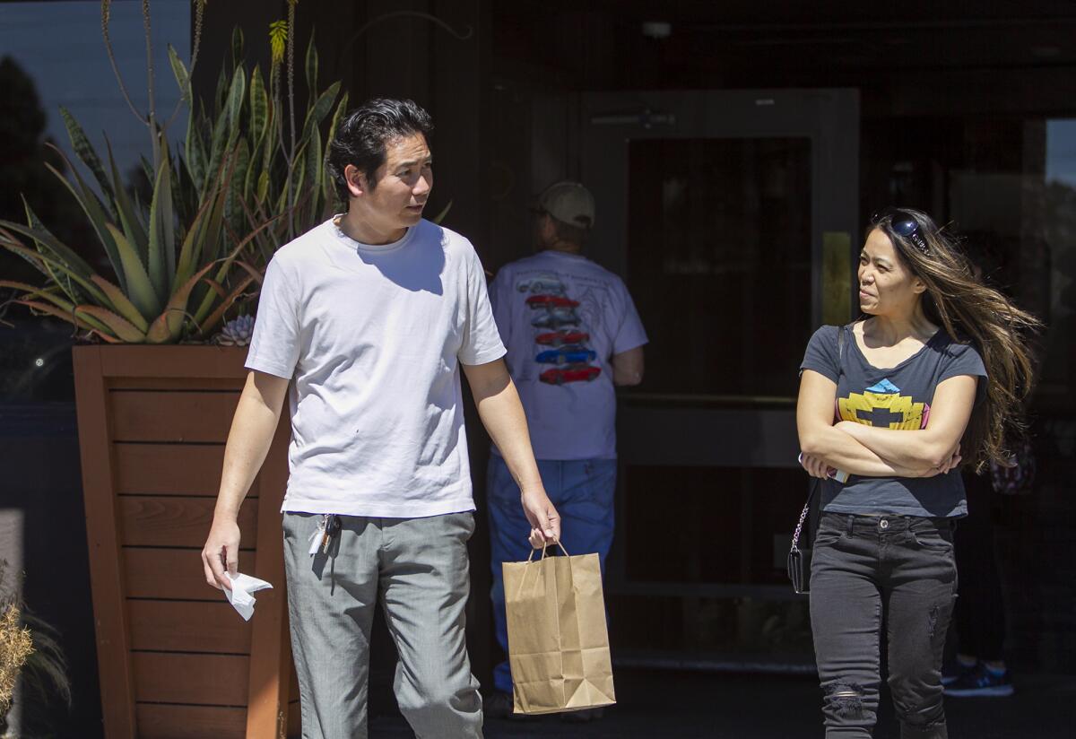 Matthew Wu and Toni Ann Moore leave the Recess Room restaurant in Fountain Valley after receiving a free lunch Friday.