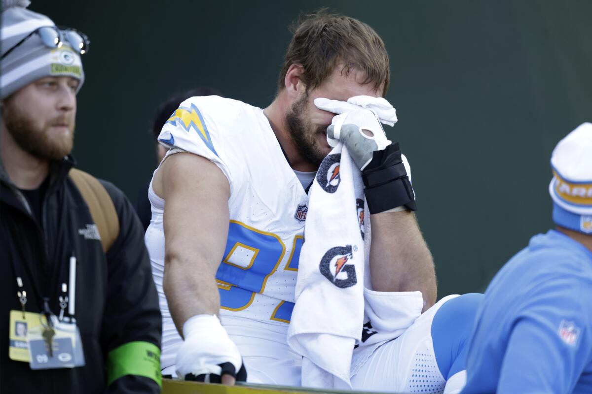 Chargers linebacker Joey Bosa grimaces as he's taken by cart off the field after suffering an apparent foot injury.