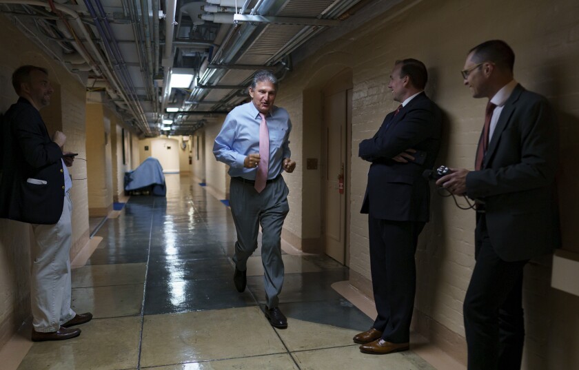 Sen. Joe Manchin, D-W.Va., one of the key Senate infrastructure negotiators, rushes back to a basement room at the Capitol as he and other Democrats work behind closed doors, in Washington, Wednesday, June 16, 2021. (AP Photo/J. Scott Applewhite)