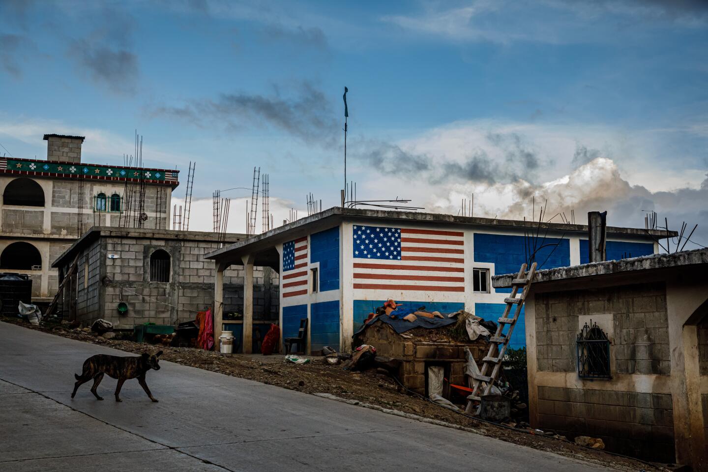 TODOS SANTOS CUCHUMAT?N, DEPARTMENT OF HUEHUETENANGO -- TUESDAY, JUNE 25, 2019: A dog walks by a home decorated with the American flag painted on its walls, near Todos Santos Cuchumat?n, Guatemala, on June 25, 2019. (Marcus Yam / Los Angeles Times)